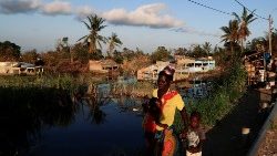 a-woman-walks-with-her-children-past-flooded--1554057279853.JPG
