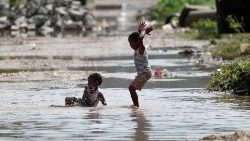 kids-are-pictured-at-a-flooded-street-during--1554906562047.JPG