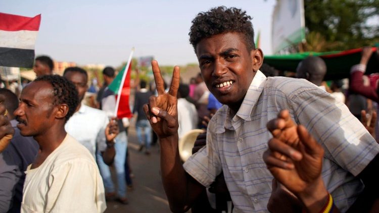Sudanese demonstrators arrive outside the Defence Ministry in Khartoum to protest against the army's announcement that President Omar al-Bashir would be replaced by a military-led transitional council.