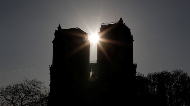Východ slunce za věžemi požárem poničené katedrály Notre Dame v Paříži (17. 4. 2019)