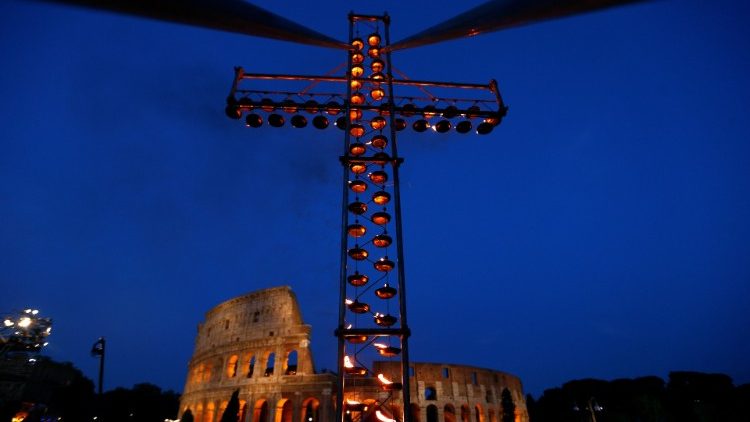A cross lit up with candles is seen in front of the Colosseum before the Via Crucis (Way of the Cross) procession during Good Friday celebrations in Rome