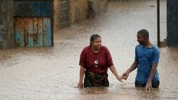 a-man-helps-a-woman-through-a-flooded-neighbo-1556486114874.JPG