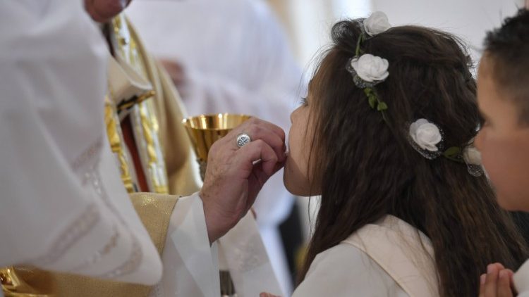 Los niños reciben la primera comunión de manos del Papa Francisco 