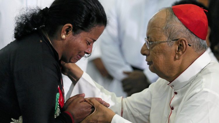 Le cardinal Ranjith réconfortant une femme dont une partie de la famille a péri dans les attentats.