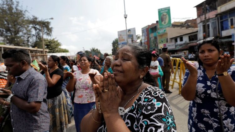 Des fidèles en prière devant l'église Sant’Antonio de Colombo, frappée par les attentats de Pâques, le 21 avril dernier.