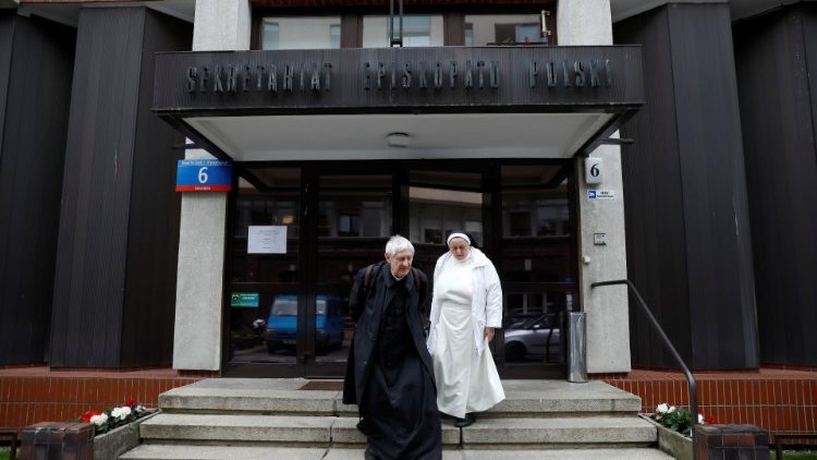 A priest and a nun walk out from the Polish Episcopate headquarters in Warsaw