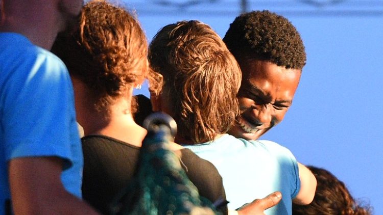 A migrant plucked from the Mediterranean embraces a crew member of a rescue ship 