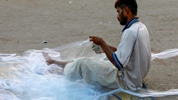 En pakistansk man förbereder nät inför fisket