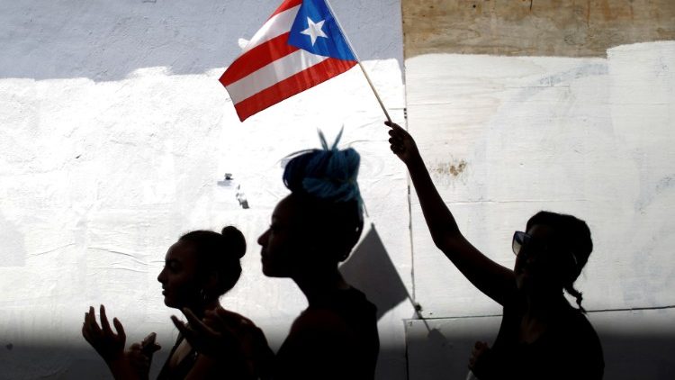 A woman waves a Puerto Rican flag in San Juan, Puerto Rico