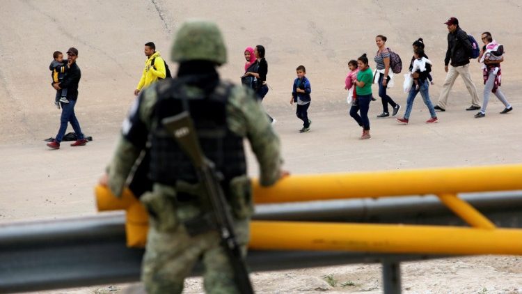Un membre de la Garde national observe un groupe de migrants qui vient de passer à El Paso