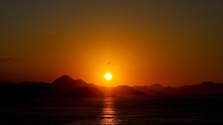 Airplane is seen in the sky during sunrise in Rio de Janeiro