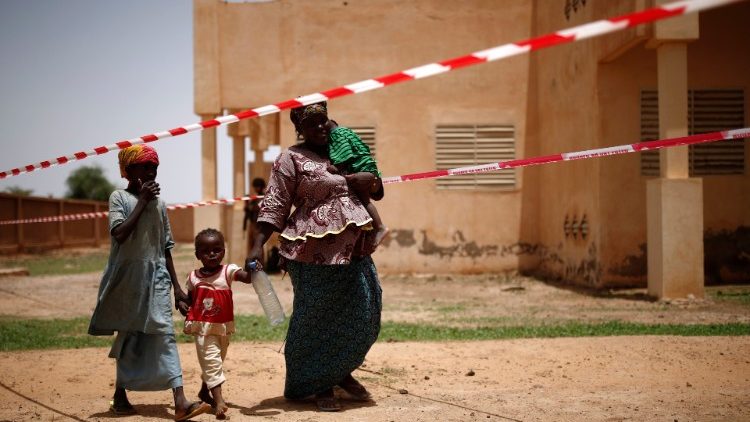 Kinder und Frauen erreichen eine Klinik in Mali