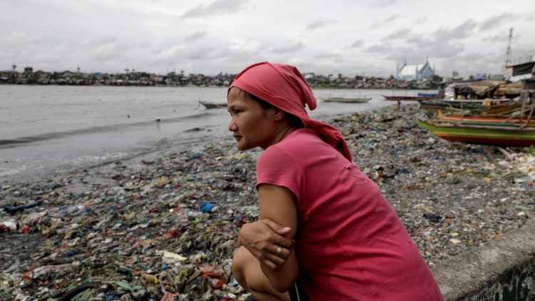 फिलीपींस में संमुद्र तट से कचरा उठानेवाली एक महिला