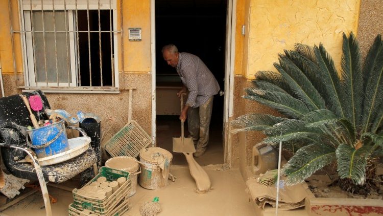 A man removes mud from his house after a flood caused by torrential rains in Orihuela