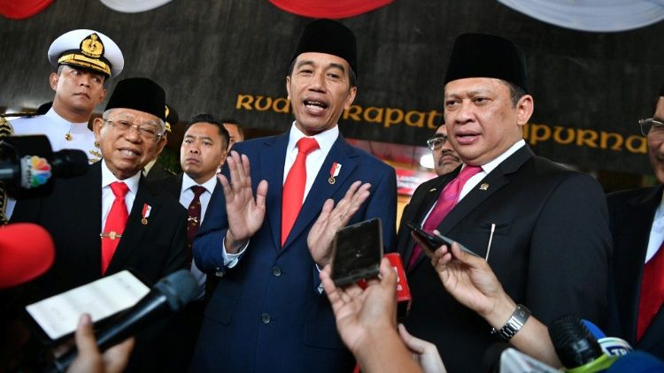 Indonesian President Joko Widodo and his Vice President Ma'ruf Amin talk to journalists after their inauguration and a swearing-in ceremony at the House of Representatives building in Jakarta