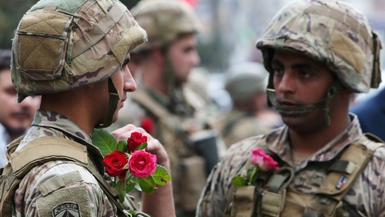 Des militaires libanais portant des roses offertes par les manifestants à Nabatieh, au sud du Liban, le 24 octobre 2019.