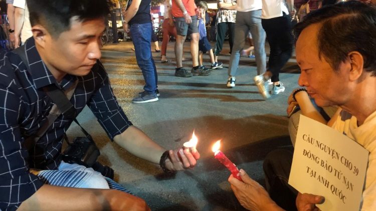 Vietnamese residents light candles during a prayer for 39 people found dead in the back of a truck near London, in front of Hanoi Cathedral in Hanoi
