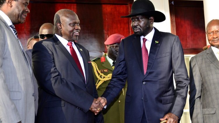 Riek Machar shakes hands with President Salva Kiir
