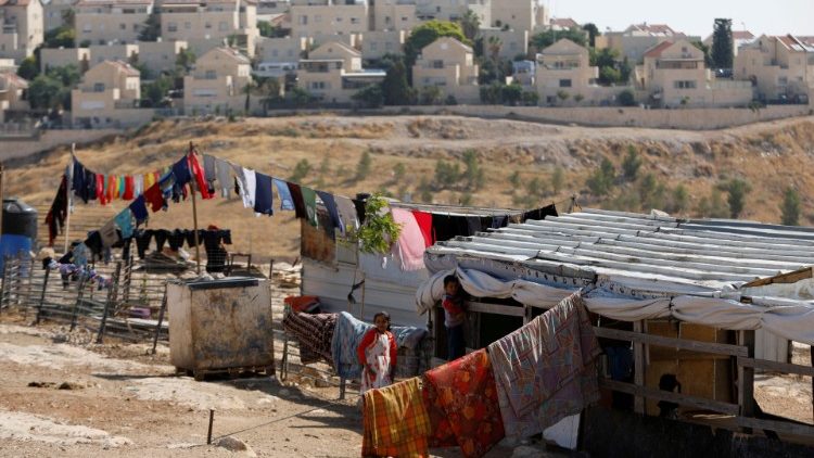 Palestinian families in Elzariya townwith the Jewish settlement of Maale Adumin in the background in the Israeli-occupied West Bank