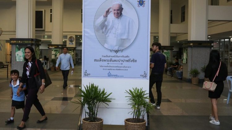 People walk pass a poster of Pope Francis in the Holy Redeemer Church in Bangkok,