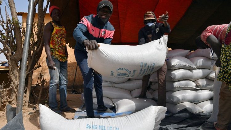 Workers carry the aid provided by the World Food Programme (WFP) for distribution in Pissila,  Burkina Faso