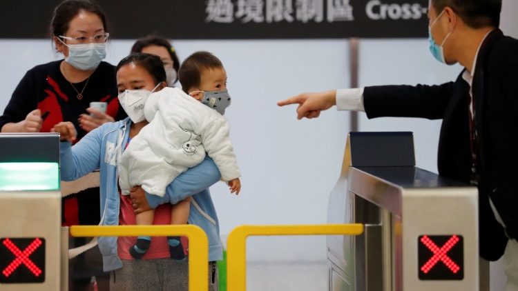 Passengers wear masks to prevent an outbreak of a new coronavirus, as they arrive at Hong Kong West Kowloon High Speed Train Station Terminus, before temporary closing, following the coronavirus outbreak in Hong Kong