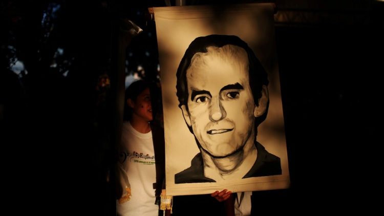 Estudante salvadorenho leva retrato do sacerdote jesuítas Ignacio Ellacuría, assassinado em 16 de novembro de 1989
