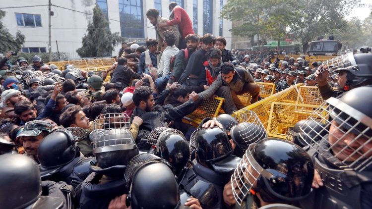 Manifestantes tratan de cruzar las barricadas policiales durante una protesta contra una nueva ley de ciudadanía 