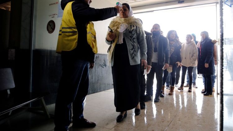 Border official checks the temperature of passengers at a border crossing 