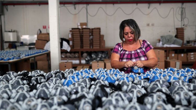 Una empleada pone rayas en mascarillas protectoras en la fábrica de Destra Brasil en Sao Paulo.