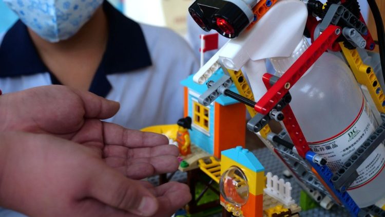 Un estudiante de primaria utiliza un dispensador de desinfectante autoconstruido, controlado por un sensor de movimiento, montado con piezas de Lego