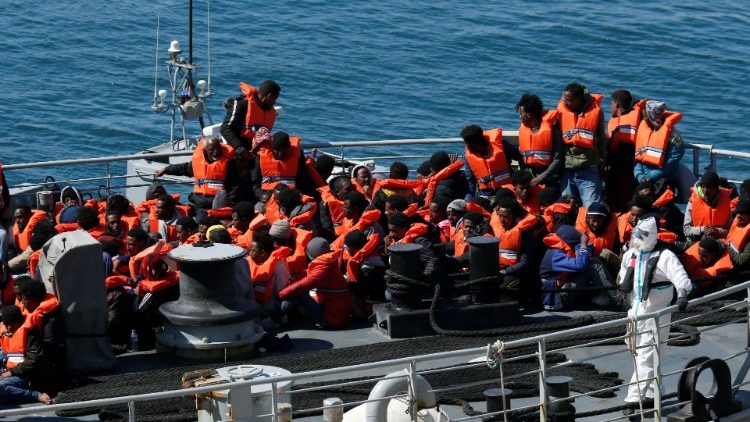 Soldados de las Fuerzas Armadas de Malta con ropa protectora contra una posible infección de coronavirus con los migrantes rescatados en un barco militar 