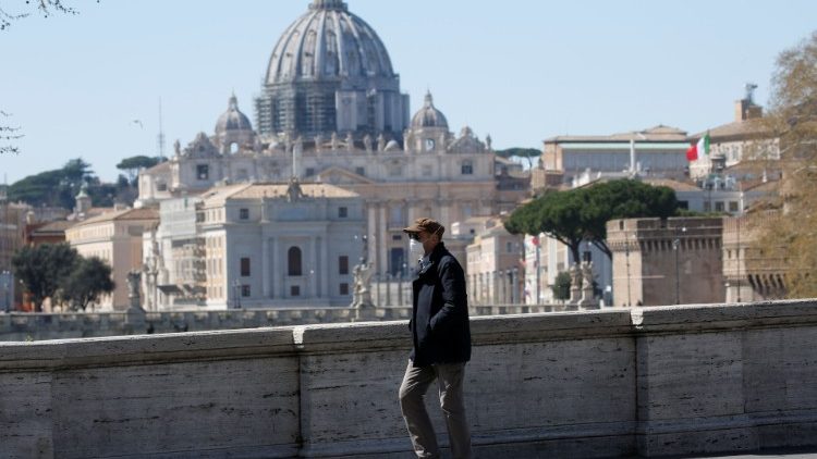 A man wearing a protective mask walks near St. Peter's Basilica, as Italy tightens measures to try and contain the spread of coronavirus disease (COVID-19), in Rome