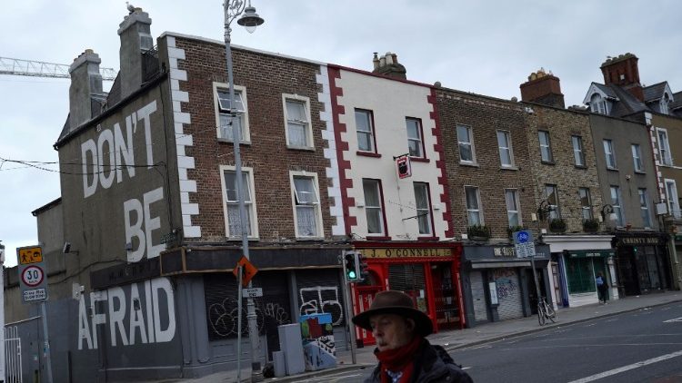 Passer by walks by building which reads "Don't be afraid" amid coronavirus disease (COVID-19) in Dublin
