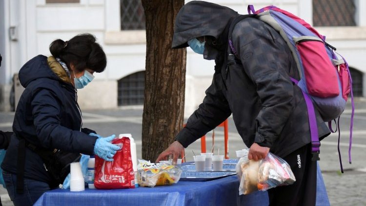 A volunteer hands out breakfast to a man in Rome