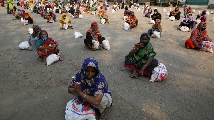 Bengalesas aguardam para receber surprimentos do governo, mantendo a distância de segurança uma da outra