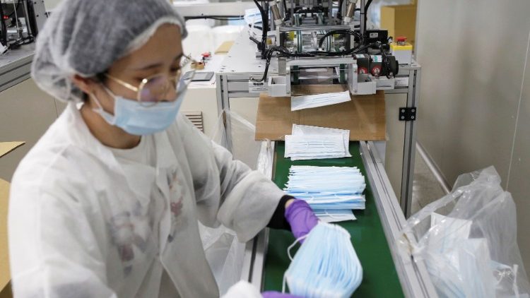 Worker collects surgical masks on the production line in a factory in Taoyuan