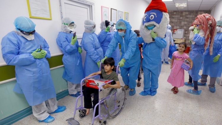 Médicos y voluntarios entretienen a niños con coronavirus en Iraq.