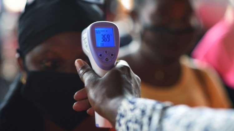 Die Temperatur der Besucher eines Marktes in Ouagadougou, Burkina Faso, wird gemessen
