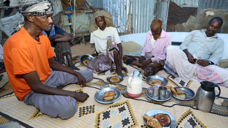 Displaced Somalis eat at a makeshift camp near Mogadishu