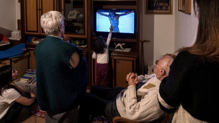Uma família italiana segue uma transmissão do Papa em pleno lockdown de março de 2020