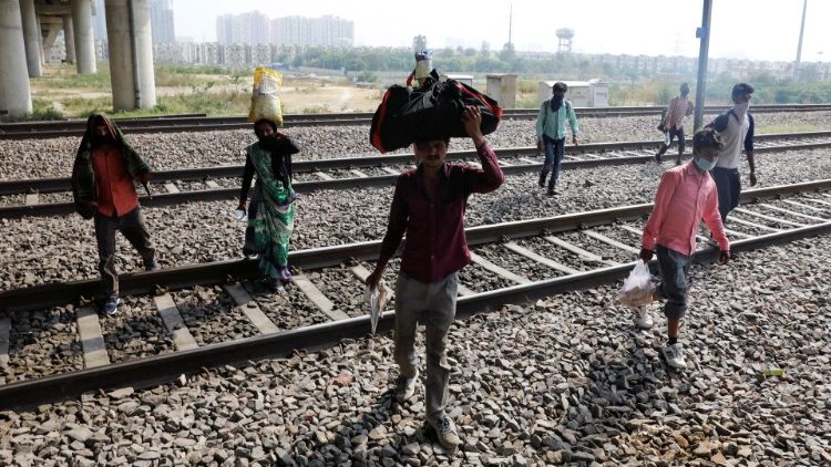 Indian migrant workers carrying their belongings on their way home