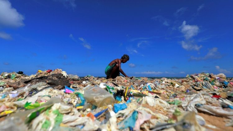 A volunteer collects rubbish on the beach on World Environment Day, Sri Lanka