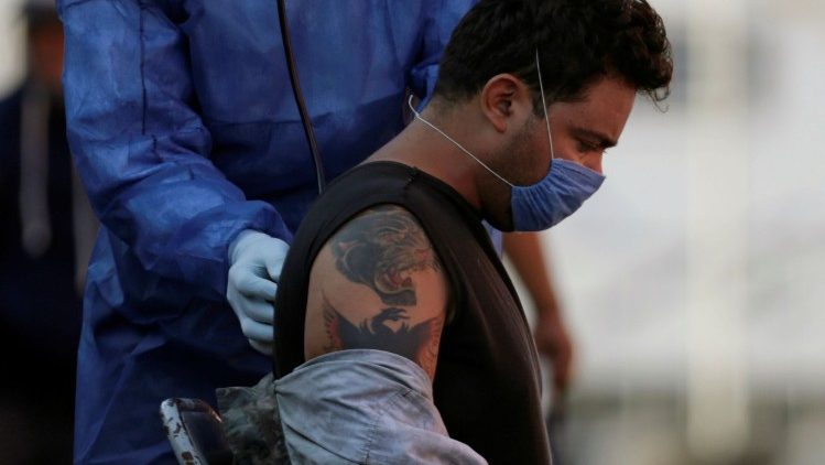 A medical worker measures vital signs of a migrant patient before he was transferred to hospital, outside the migrant shelter Casa INDI, where some migrants have been infected by the coronavirus disease COVID-19, in Monterrey