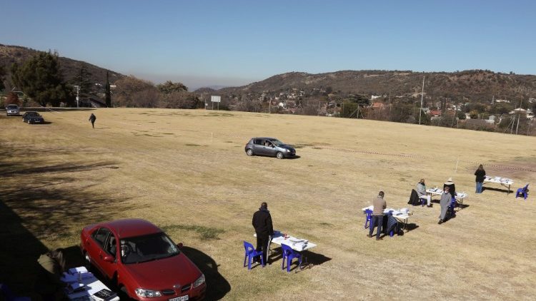 Lehrer warten in Südafrika an einem Drive-Through, wo Eltern ihnen die Hausaufgaben ihrer Kinder überreichen sollen