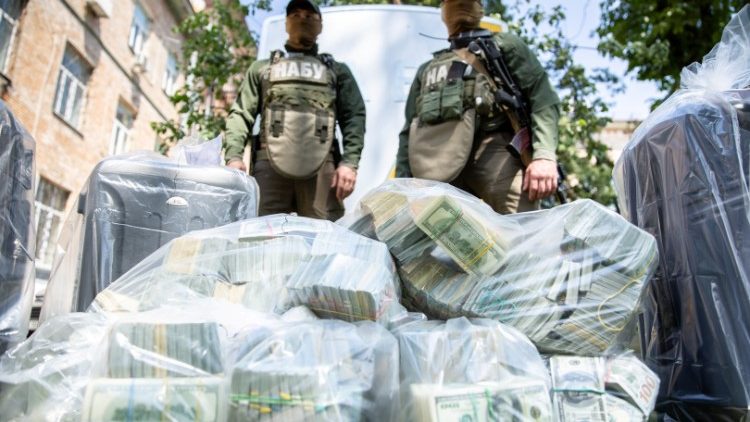 Officers of the National Anti-Corruption Bureau of Ukraine stand next to plastic bags filled with seized U.S. Dollar banknotes in Kiev