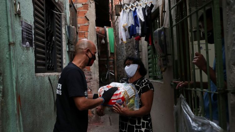 Famílias recebendo doação de alimentos em favela de São Paulo