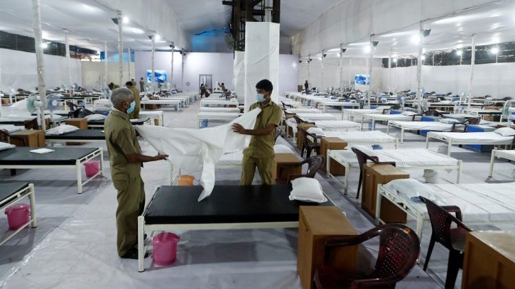 Workers prepare a bed at a recently constructed quarantine facility for patients diagnosed with the coronavirus disease (COVID-19) in Mumbai