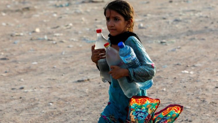 Menina com garrafas d'água em Karachi