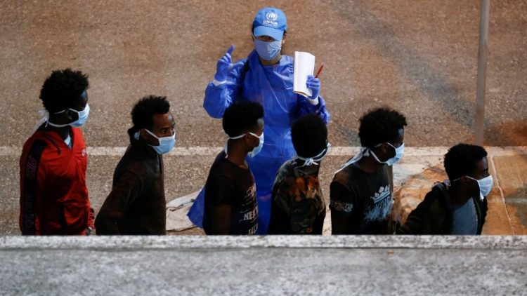 Migrants rescued by Maltese Armed Forces are checked by a UNHCR official upon their arrival in La Valletta